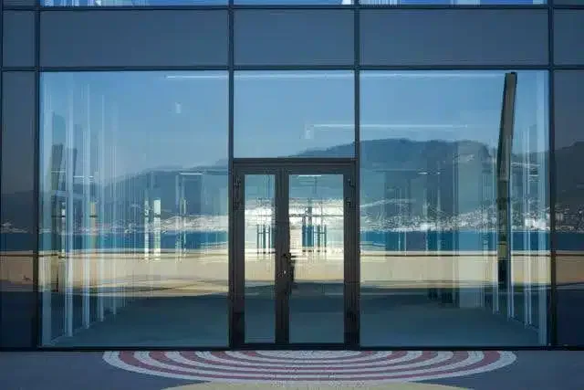 A large glass door stands above a circular patterned floor creating an elegant entrance