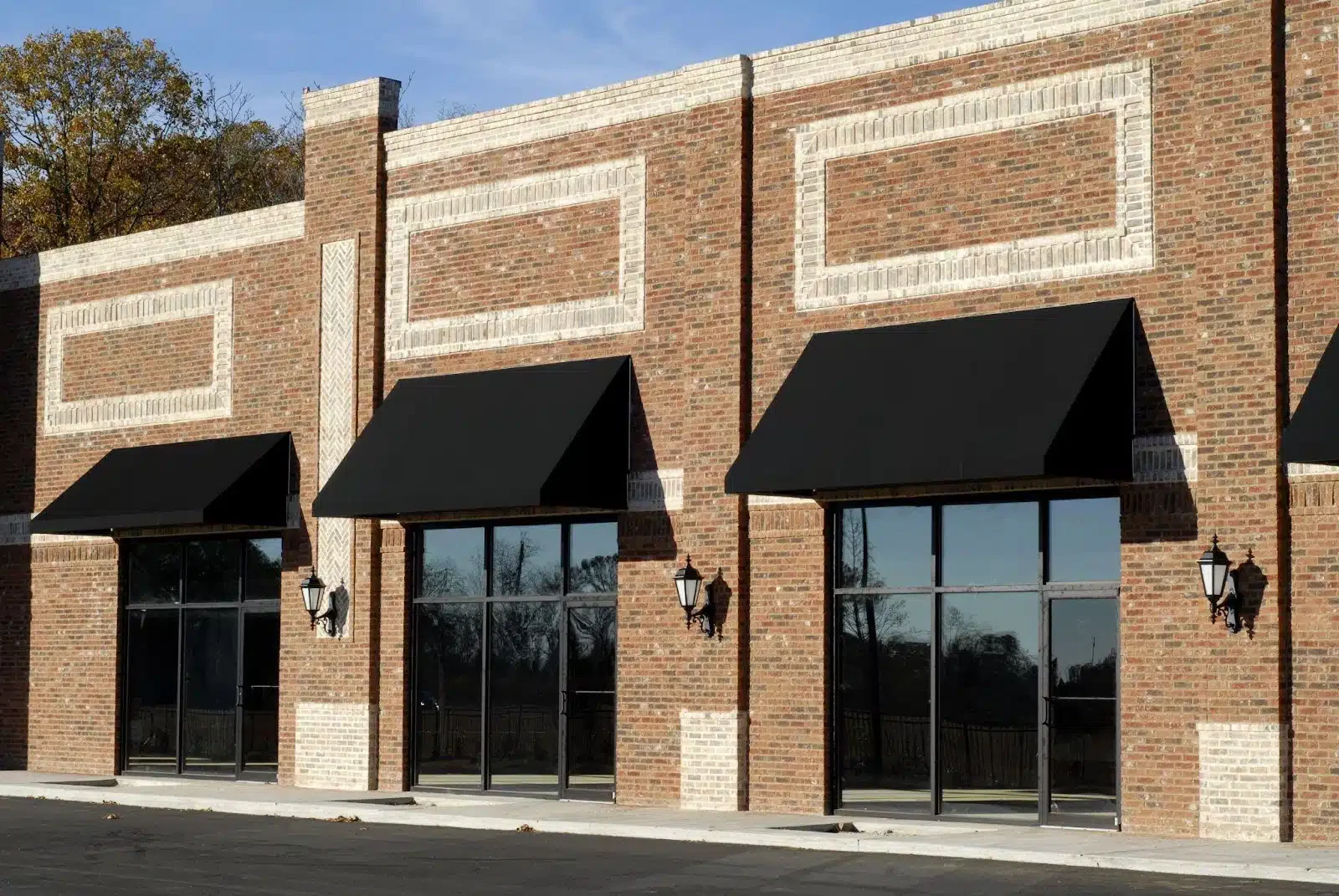 A brick building featuring black awnings over its windows showcasing a classic architectural style