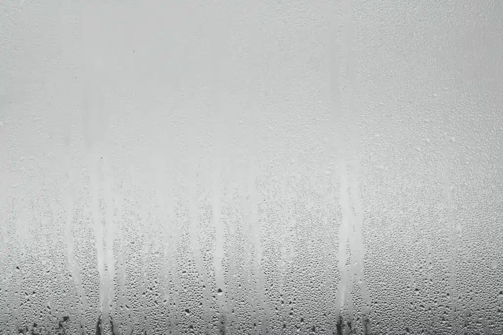 Close-up of a window with water droplets, highlighting condensation patterns