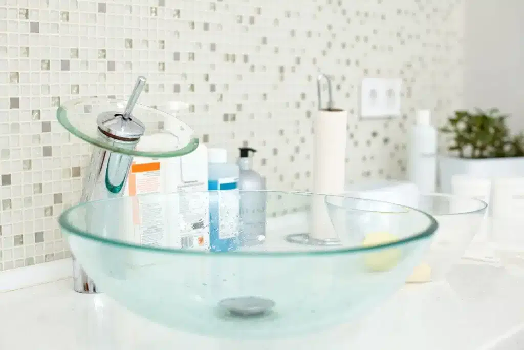 A clear glass bowl placed on a kitchen countertop reflecting light and showcasing its smooth surface