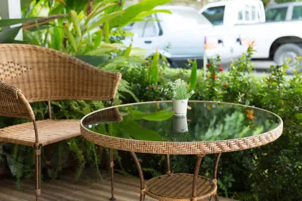 Patio arrangement featuring wicker chair and table.