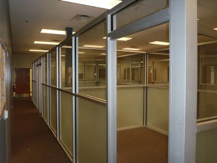 Glass-walled hallway with doors in a commercial setting.
