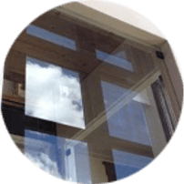 A windowpane made of glass, revealing a scenic sky view.