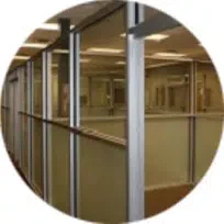 Glass-walled hallway with doors in a commercial setting.