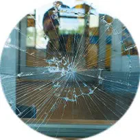 A broken window with a reflection of a person in it. Glass Repair.