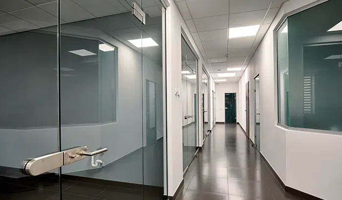 A bathroom with a glass shower door and a toilet.
