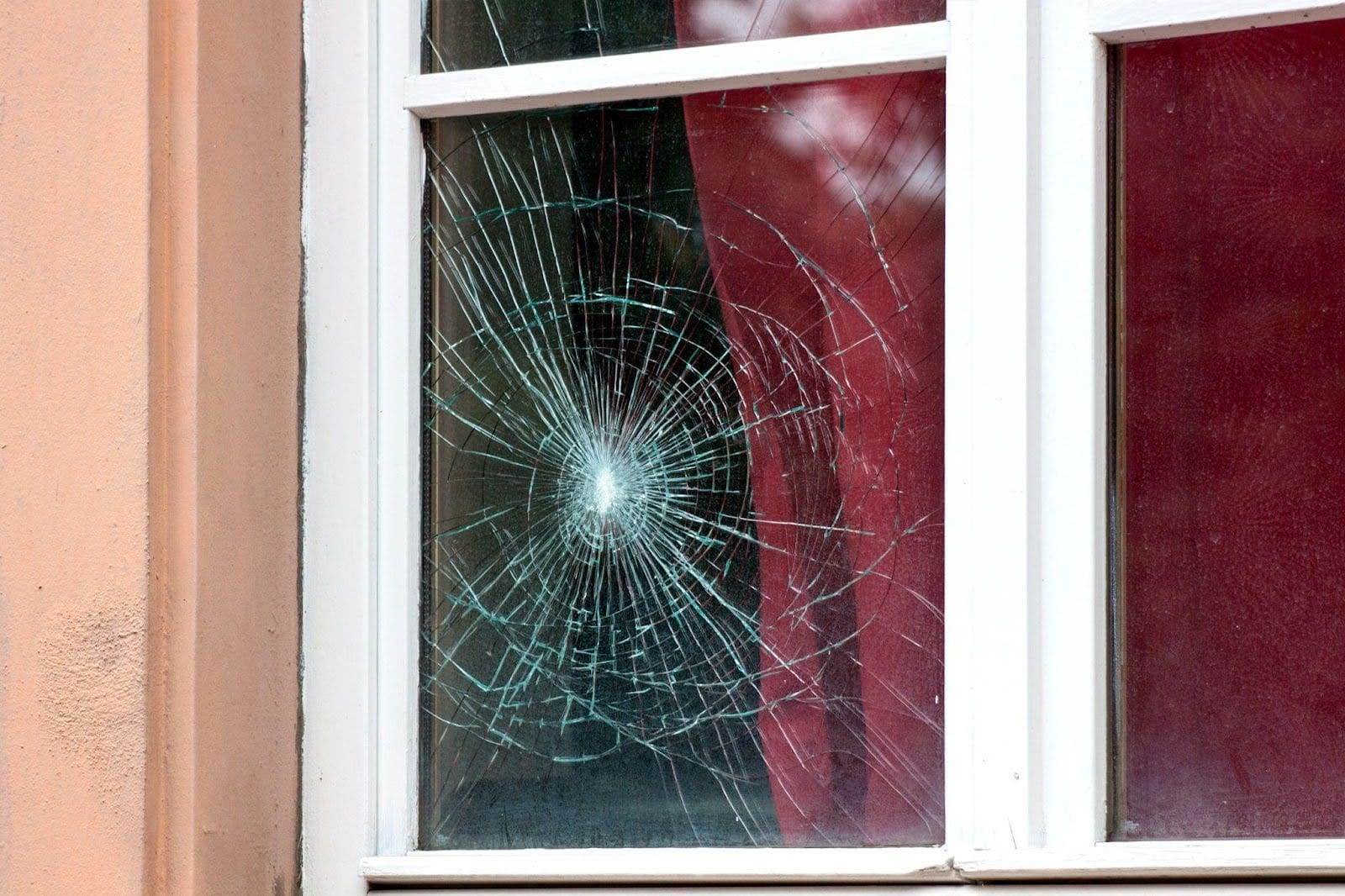 A shattered window symbolizing destruction and the need for repair