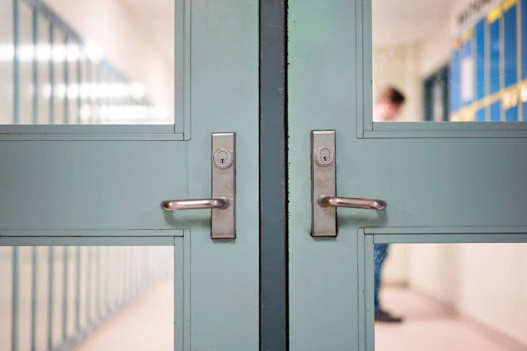 A man strides down a hallway, with two doors positioned along the sides, suggesting options ahead