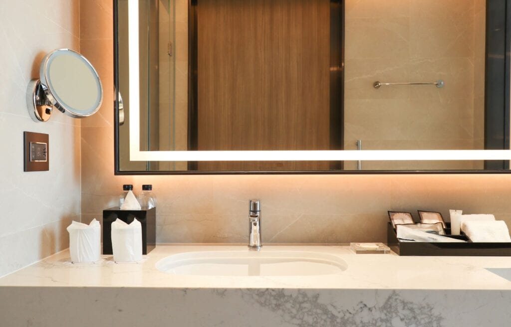 A modern bathroom featuring a stylish sink and a custom mirror reflecting the serene ambiance of the space.