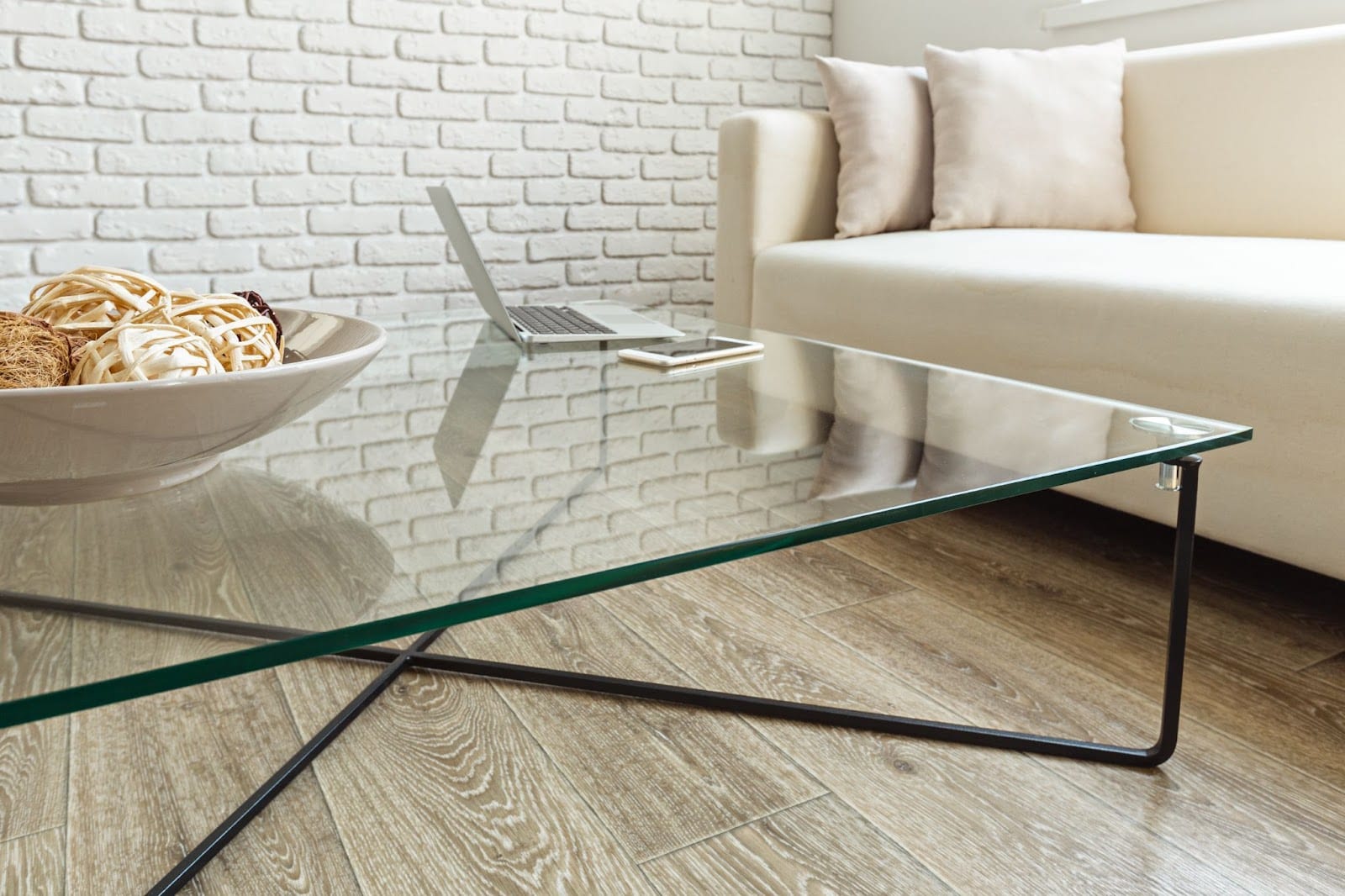 A modern glass coffee table with chipped glass in need of repair.
