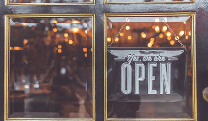 Storefront Glass with open sign displayed in window.