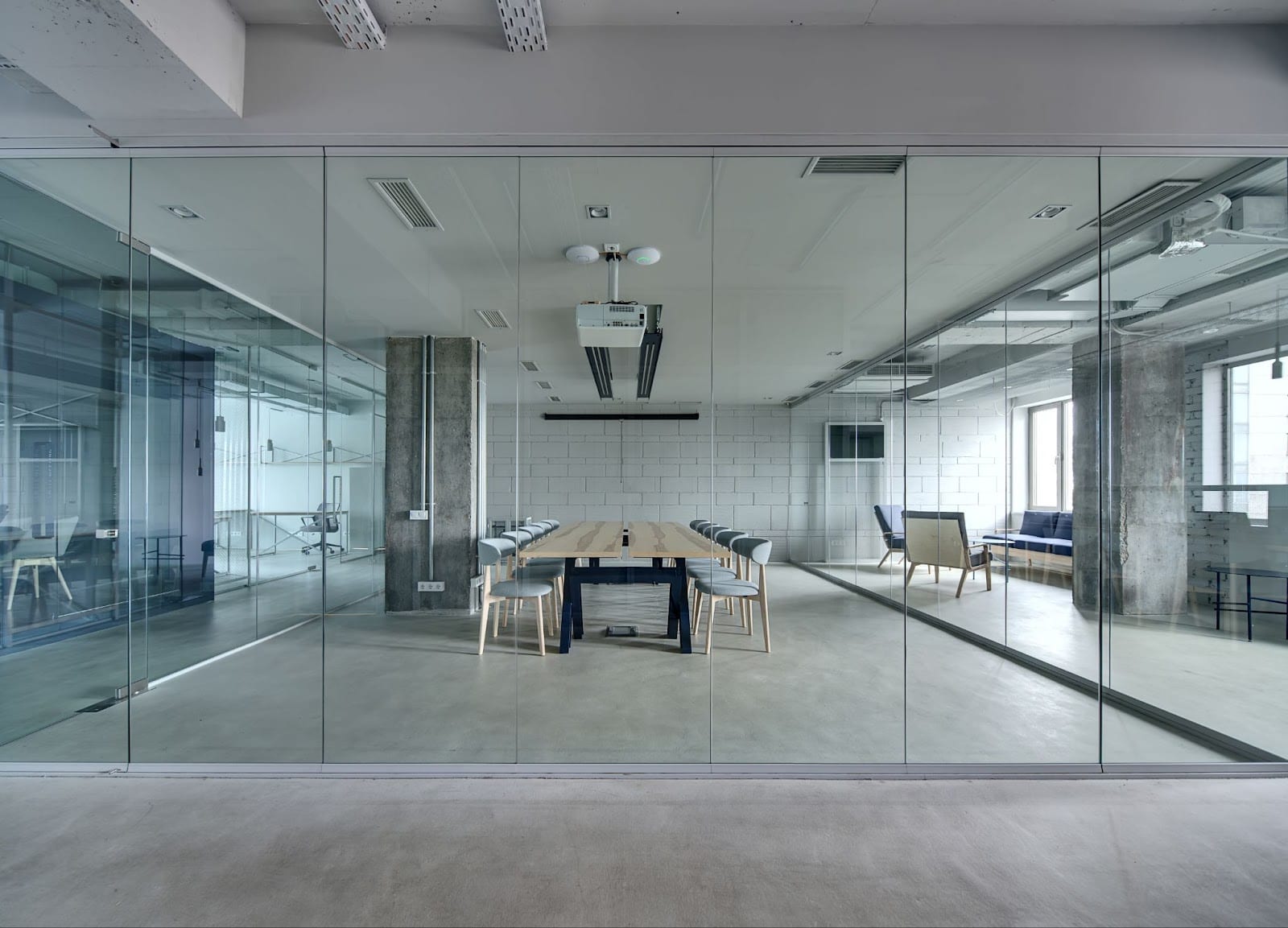 A large office with glass walls, showcasing a contemporary table and chairs, designed for collaboration and productivity.