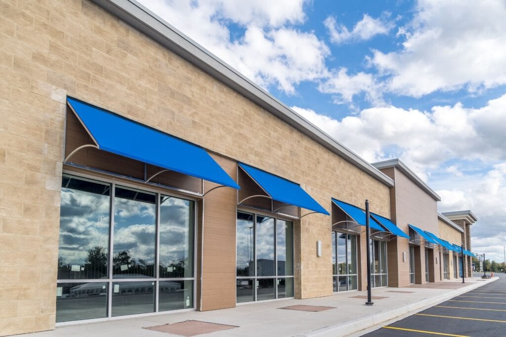 A large building featuring blue awnings, ideal for storefront glass repair services in the vicinity.