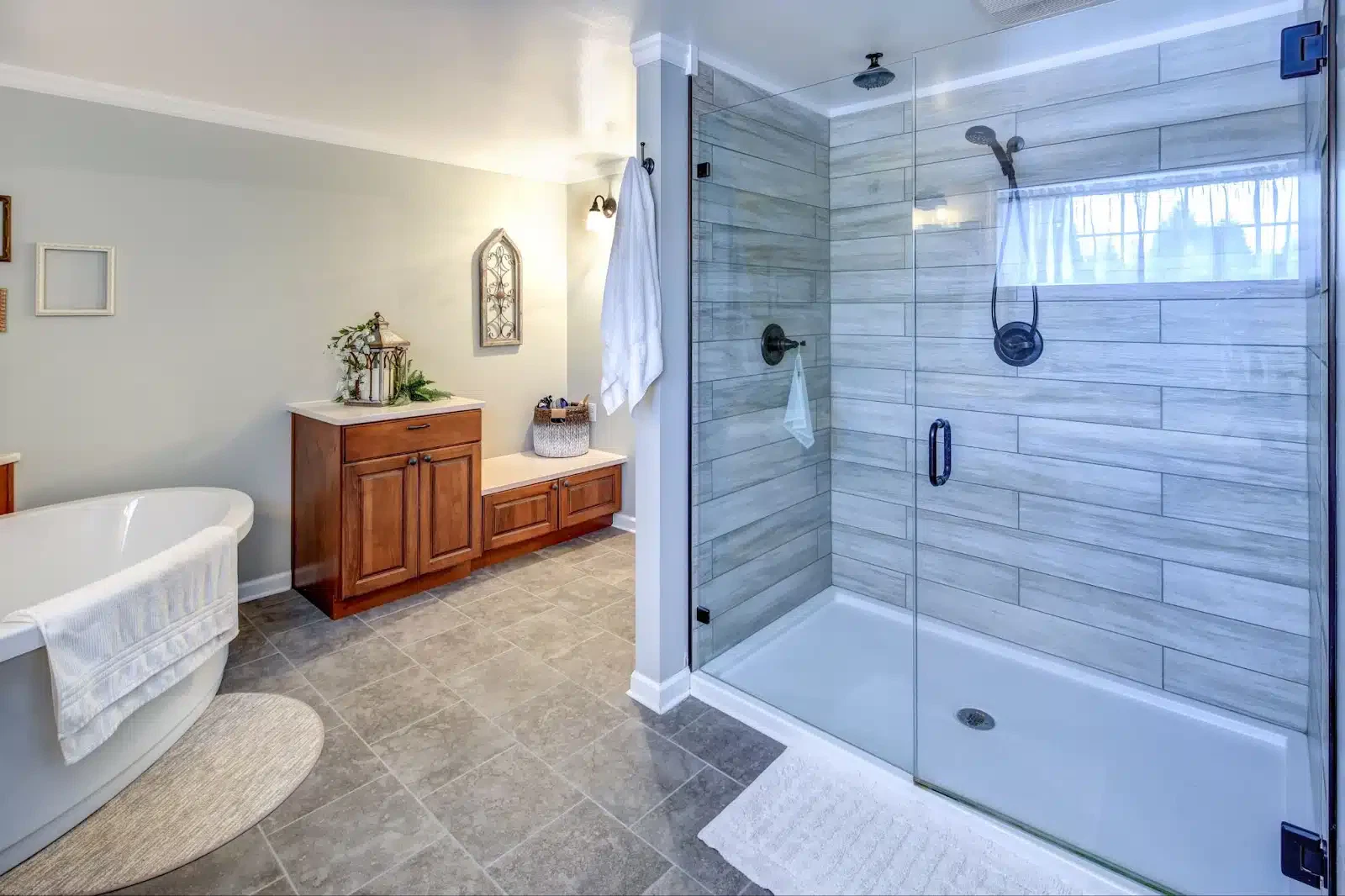 A modern bathroom featuring a walk-in shower and a tub, enclosed by elegant glass wall systems for a sleek appearance.