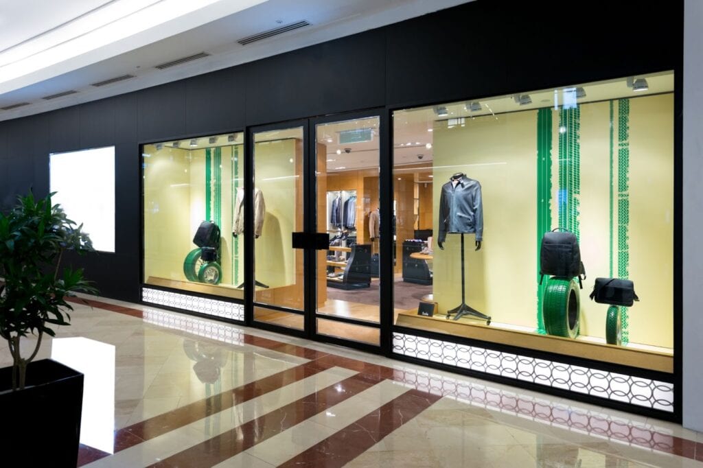 A storefront featuring a large glass door and a potted plant, highlighting storefront glass repair services available nearby.