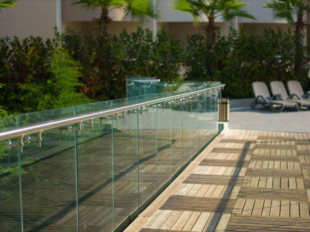 A glass railing on a wooden deck offering safety and elegance