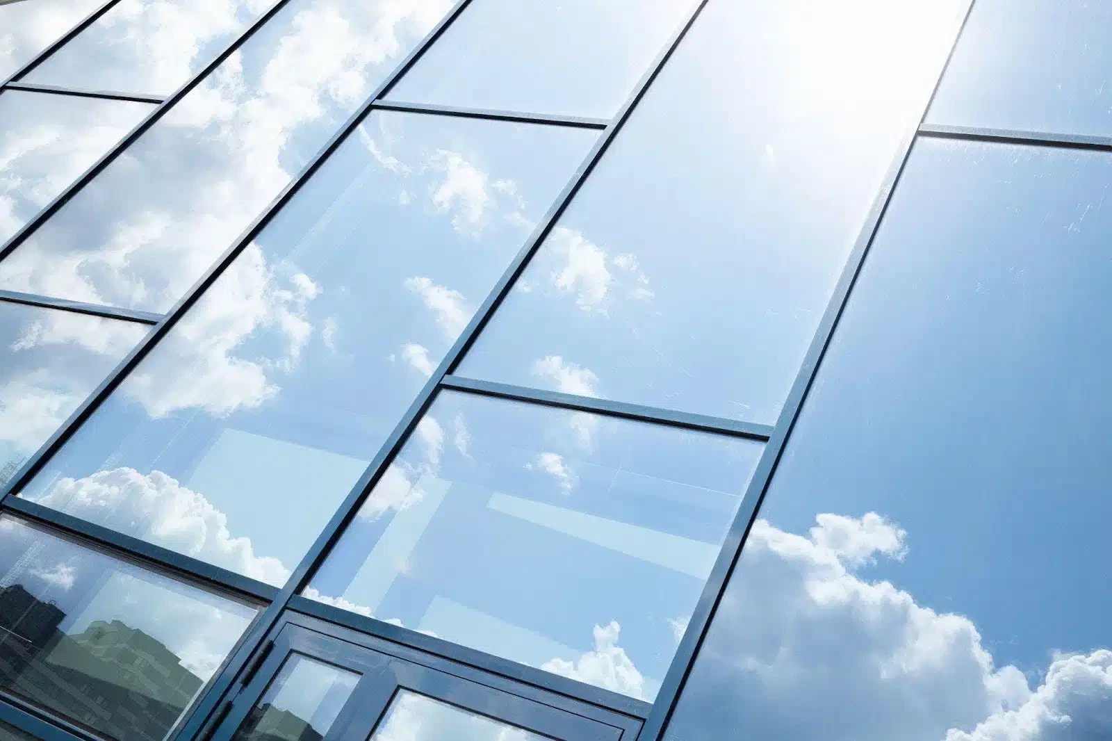 A sleek building with expansive glass windows under a sunny sky