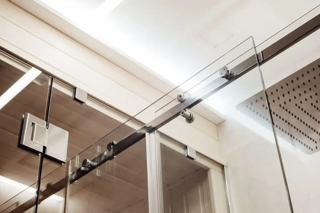 A glass shower door featuring a sleek metal frame showcasing a modern bathroom design