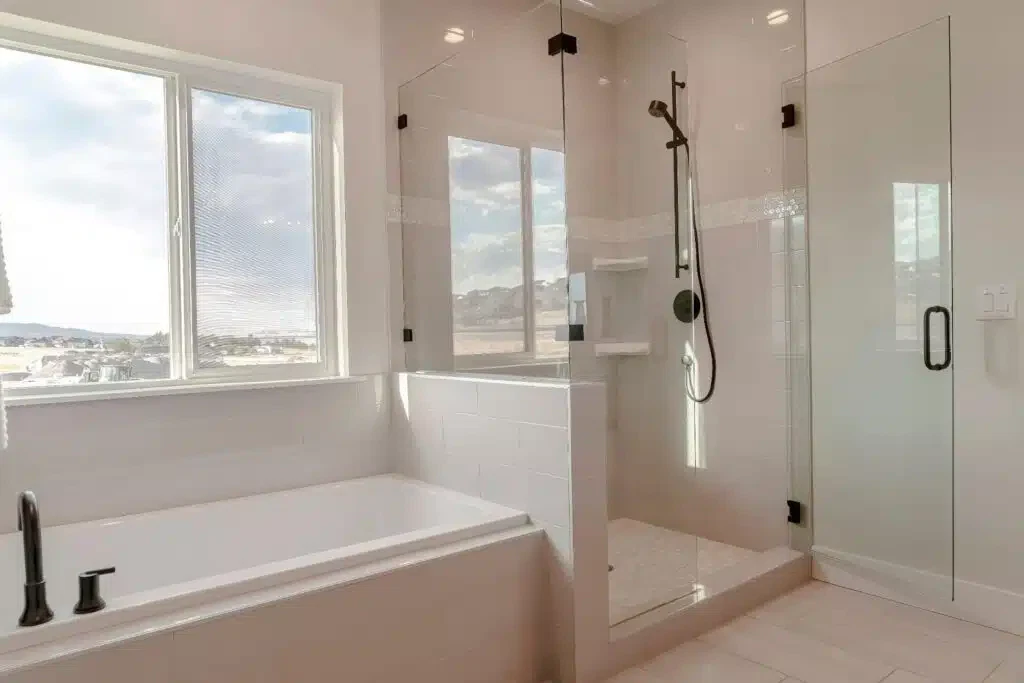 A modern bathroom featuring a glass shower door alongside a stylish bathtub