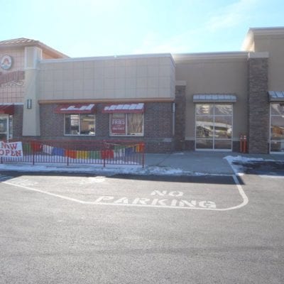 Fast food restaurant with parking lot and sign.