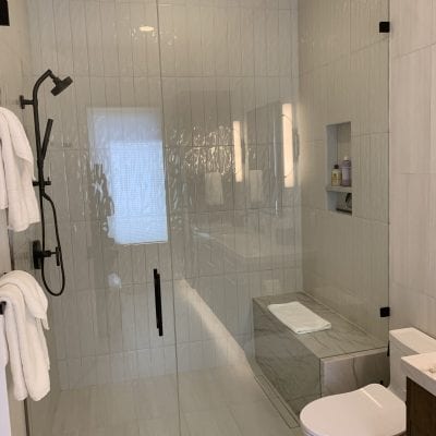 Bathroom setting with a glass shower door and a toilet.