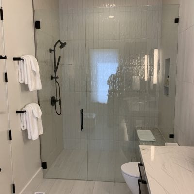 A modern bathroom with a glass shower door and a toilet.