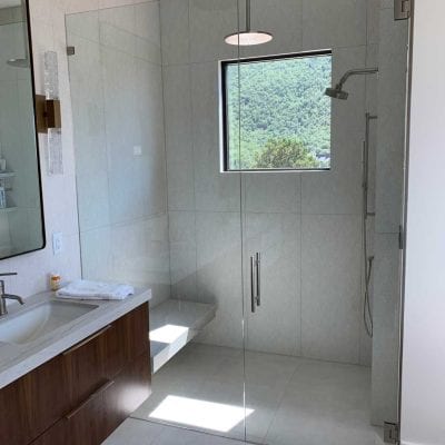 A modern bathroom featuring a glass shower door, sleek fixtures, and a clean design.