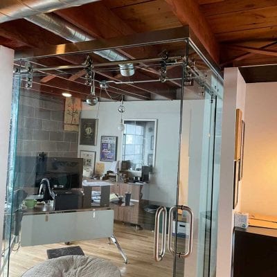 A glass-walled office with a cozy dog bed, providing a comfortable space for both work and relaxation.