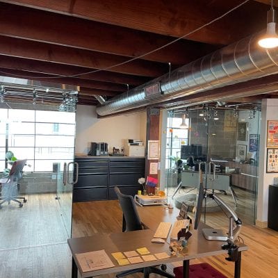 An open office with a spacious layout, featuring a desk and chairs for a productive work environment.