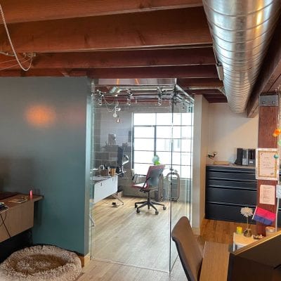 An open office with a spacious layout, featuring a desk and chairs for a productive work environment.
