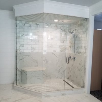 A spacious bathroom featuring a glass shower door.
