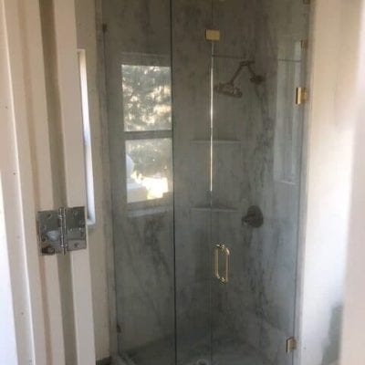 A modern bathroom with a transparent shower door and a toilet.