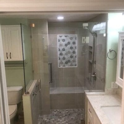 A bathroom with a shower and toilet, featuring modern fixtures and a clean design.