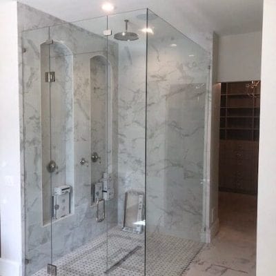 A spacious bathroom featuring a glass shower enclosure.