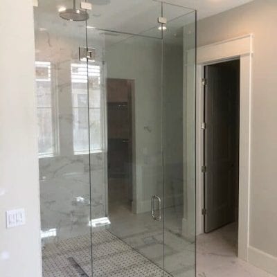 A spacious bathroom featuring a glass shower door.
