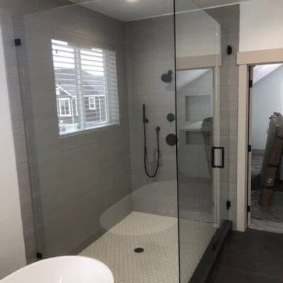 A modern bathroom with a glass shower door and a tub.