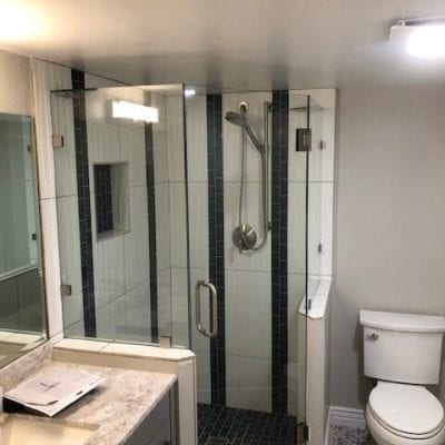 A modern bathroom featuring a shower, toilet, and sink.