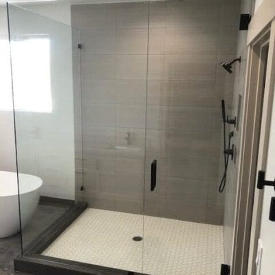 A spacious bathroom featuring a glass shower door.