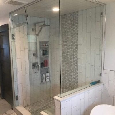 A modern bathroom with a glass shower door and a bathtub.