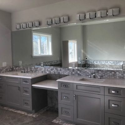 A modern bathroom with two sinks and a glass-enclosed shower.