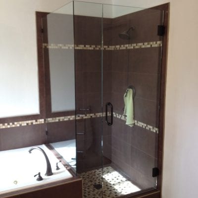 A modern bathroom with a glass shower door and a tub.