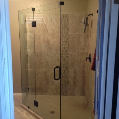 Glass shower door and toilet in a contemporary bathroom.