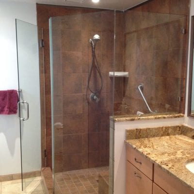 Image of a bathroom featuring a glass shower door and a stylish sink.