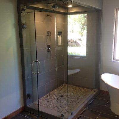 A modern bathroom with a glass shower door and a toilet.