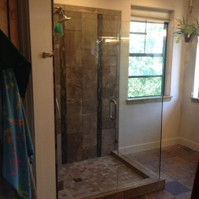 A sleek bathroom featuring a glass shower door and a toilet.