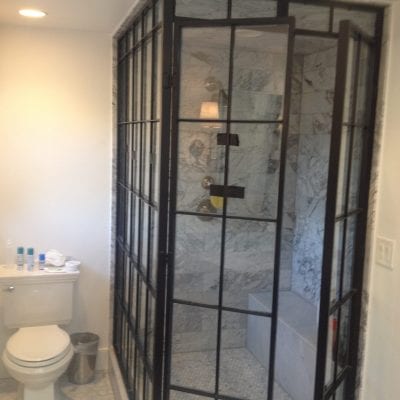 Interior of a bathroom with glass shower door and toilet.